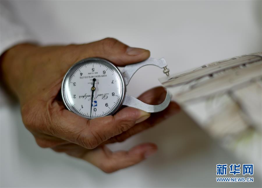 黃正南在測量制造的薄胎瓷碗厚度（3月11日攝）。