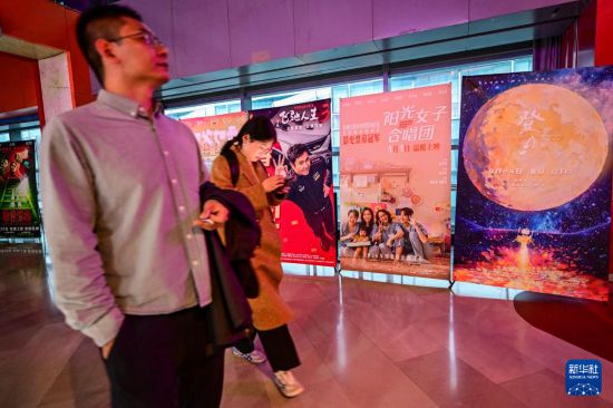 3月31日，在首都電影院西單店，觀眾從台灣電影《陽光女子合唱團》的海報旁走過。新華社記者 陳曄華 攝