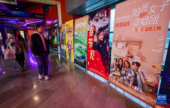 3月31日，在首都電影院西單店，觀眾從台灣電影《陽光女子合唱團》的海報旁走過。新華社記者 陳曄華 攝