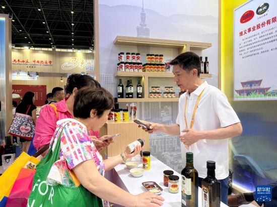 4月13日，台湾参展商（右）在第六届中国国际消费品博览会向观众介绍产品。新华社记者 陈子薇 摄