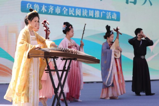 民乐手在乌鲁木齐市全民阅读周推广活动启动仪式上演奏乐曲。新华社发（石磊 摄）