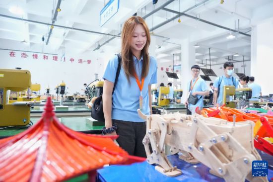 7月4日，台青何宜萱在华中科技大学工创中心欣赏学生制作的工艺品。新华社记者 马欣然 摄