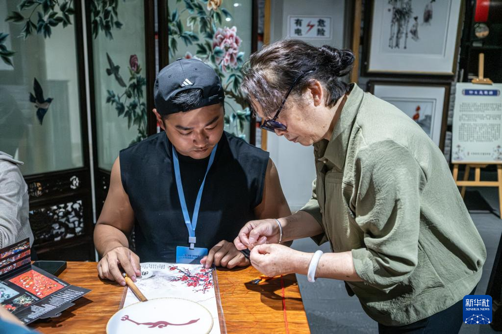 5月10日，採風團成員（左）在位於成都的一家蜀繡博物館內體驗制作蜀繡。新華社記者 孟佳 攝